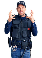 Young handsome man wearing police uniform shouting frustrated with rage, hands trying to strangle, yelling mad