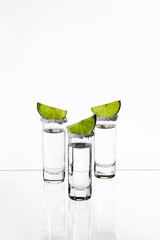 tequila shots with lime and salt on white background