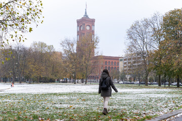 Unrecognizable young female tourist looking up at the Rotes Rathaus and the snowy surroundings