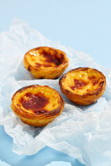 Traditional Portuguese egg tart dessert Pasteis Pastel de nata or Pasteis de Belem on blue background