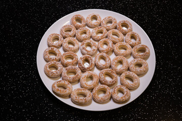 Bublik (also booblik or bublyk) it is a ring of wheat dough - a sweet dessert on a white plate and a black table
