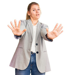 Young beautiful blonde woman wearing elegant jacket doing stop gesture with hands palms, angry and frustration expression