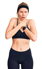 Fototapeta premium Young beautiful blonde woman wearing sportswear shouting and suffocate because painful strangle. health problem. asphyxiate and suicide concept.