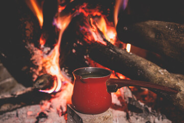 Warm by the fire, cozy winter night in the scandinavian cottage house cabin by the fireplace,...