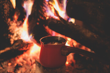 Warm by the fire, cozy winter night in the scandinavian cottage house cabin by the fireplace,...