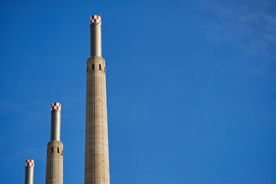 COn el cielo azul limpio de fondo tres chimeneas industriales