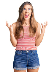 Beautiful caucasian young woman wearing casual clothes crazy and mad shouting and yelling with aggressive expression and arms raised. frustration concept.