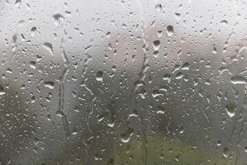 Raindrops run down the window pane. Rainy weather. Soft selective focus.
