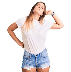 Beautiful caucasian woman wearing casual white tshirt stretching back, tired and relaxed, sleepy and yawning for early morning