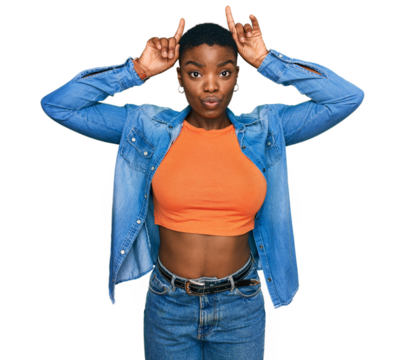 Young african american woman wearing casual clothes doing funny gesture with finger over head as bull horns