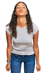 Fototapeta premium Young african american girl wearing casual clothes looking at the camera blowing a kiss on air being lovely and sexy. love expression.