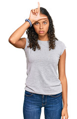 Fototapeta premium Young african american girl wearing casual clothes making fun of people with fingers on forehead doing loser gesture mocking and insulting.