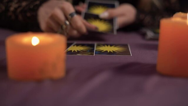 Tarot cards on wooden table and fortune teller hands, close up. Reading future