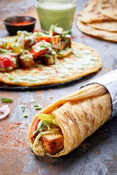 Paneer Tikka paratha roll kathi shawarma wrap with dipping sauce isolated on background side view of indian fastfood