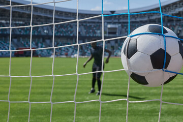 soccer player kicks the ball into the goal at the stadium - Powered by Adobe