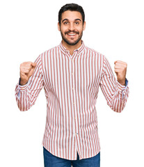 Young hispanic man wearing business shirt celebrating surprised and amazed for success with arms raised and open eyes. winner concept.