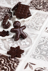 Homemade dark chocolate, Christmas praline gingerbread man, chocolate bar, snowflake, candy cane.
