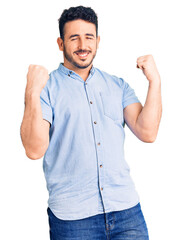 Young hispanic man wearing casual clothes very happy and excited doing winner gesture with arms raised, smiling and screaming for success. celebration concept.