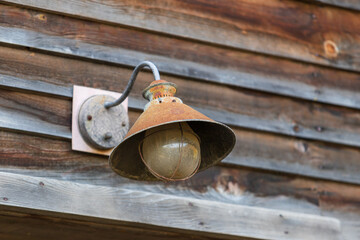 An old tin lamp above the entrance of a farm building.