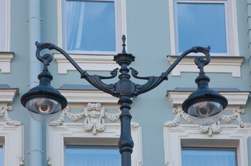 Beautiful electric street lamp against the background of the windows of an ancient building
