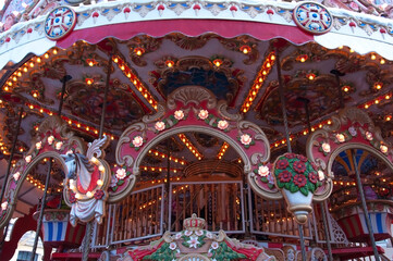 Illuminated bright beautiful carousel with toys and flowers at the festive winter fair