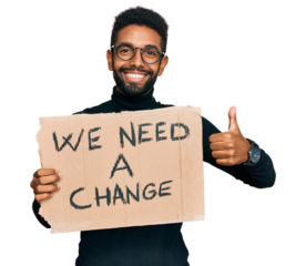 Young african american man holding we need a change banner smiling happy and positive, thumb up doing excellent and approval sign