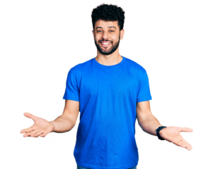 Young arab man with beard wearing casual blue t shirt smiling cheerful with open arms as friendly welcome, positive and confident greetings