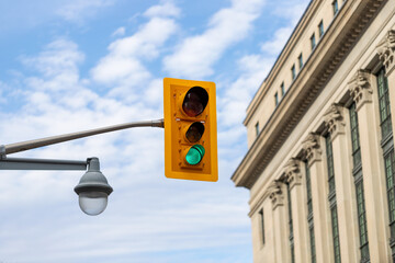 Traffic light against sky and tall historical building in downtown Ottawa, Canada