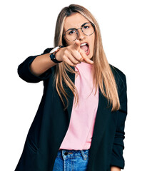Hispanic young woman wearing business jacket and glasses pointing displeased and frustrated to the...
