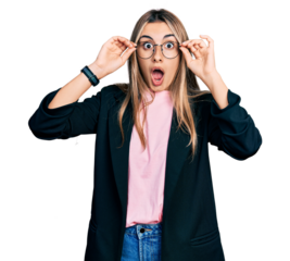 Hispanic young woman wearing elegant jacket and glasses afraid and shocked with surprise and amazed expression, fear and excited face.
