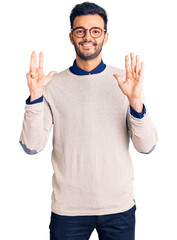 Young handsome hispanic man wearing elegant clothes and glasses showing and pointing up with fingers number nine while smiling confident and happy.