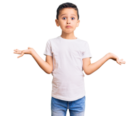 Little cute boy kid wearing casual white tshirt clueless and confused expression with arms and hands raised. doubt concept.
