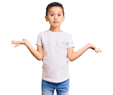 Little cute boy kid wearing casual white tshirt clueless and confused expression with arms and hands raised. doubt concept.