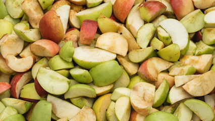 Fresh apples harvest background. Sliced red and yellow apple wedges for a healthy snacks or to make an apple pie, jam, cider or juice outdoors.