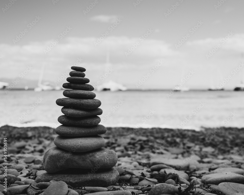 Poster grayscale closeup of a stack of rocks on the beach