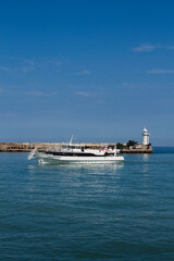 Fototapeta premium a ship in the black sea on the background of a lighthouse