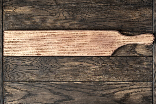 Empty long cutting board on oak wooden table top view. Food background