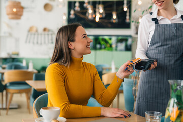 Young woman pays her bill with a credit card