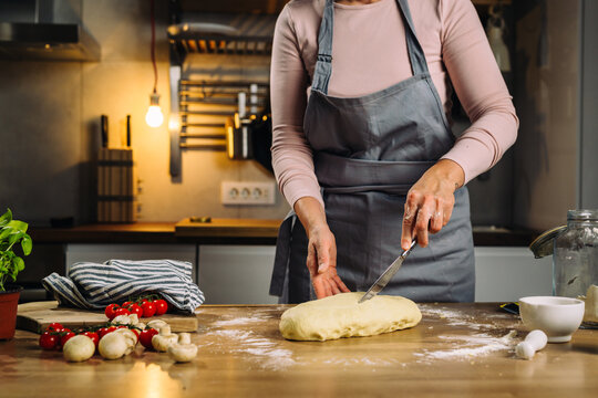 Woman Cuts Dough Into Smaller Peaces