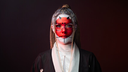 A young woman in fantastic makeup and an Asian kimono, the image of a cyber geisha. Close-up portrait