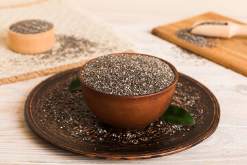 Chia seeds in bowl and spoon on colored background. Healthy Salvia hispanica in small bowl. Healthy superfood