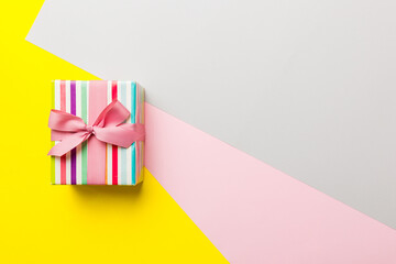 holiday paper present tied pink ribbon bow top view with copy space. Flat lay holiday background. Birthday or christmas present. Christmas gift box concept with copy space