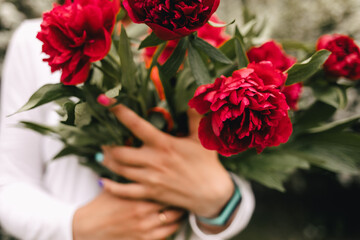 Fototapeta na wymiar bouquet of peonies in hands