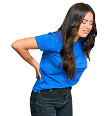 Beautiful brunette young woman wearing casual clothes suffering of backache, touching back with hand, muscular pain
