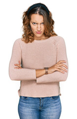 Beautiful young caucasian woman wearing casual sweater skeptic and nervous, disapproving expression on face with crossed arms. negative person.