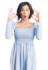 Young beautiful girl wearing casual clothes looking surprised and shocked doing ok approval symbol with fingers. crazy expression