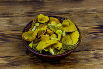 Tasty marinated mushrooms on wooden table