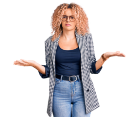 Young blonde woman with curly hair wearing business jacket and glasses clueless and confused with open arms, no idea concept.