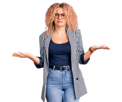 Young blonde woman with curly hair wearing business jacket and glasses clueless and confused with open arms, no idea concept.
