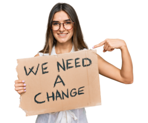 Young hispanic woman holding we need a change banner pointing finger to one self smiling happy and proud